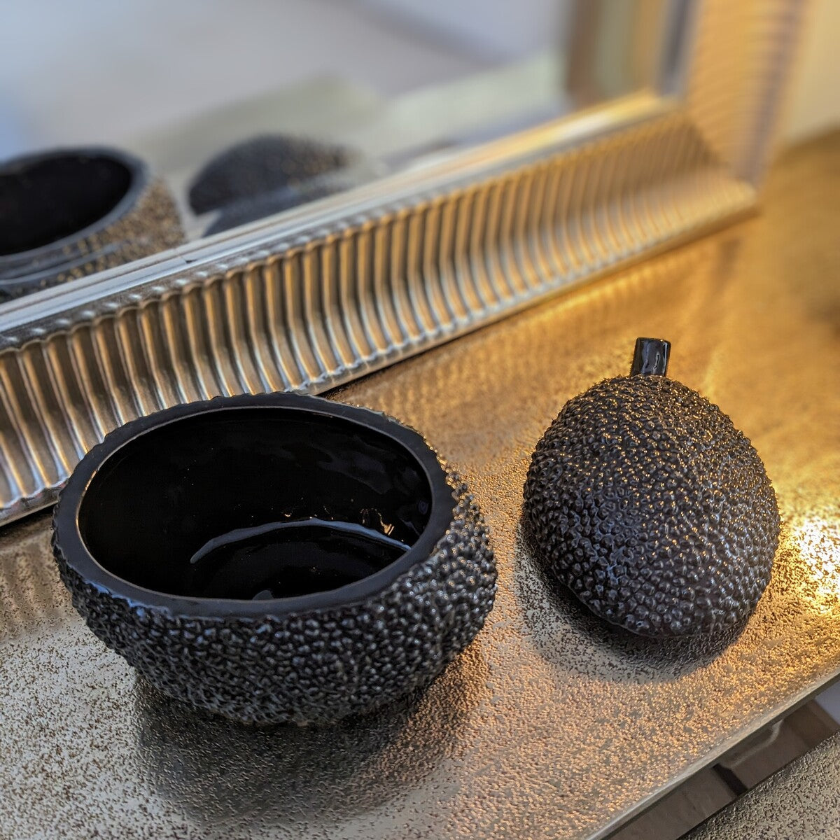 boite en ceramique noire avec un intérieur lisse et brillant en forme de fruit, de durian