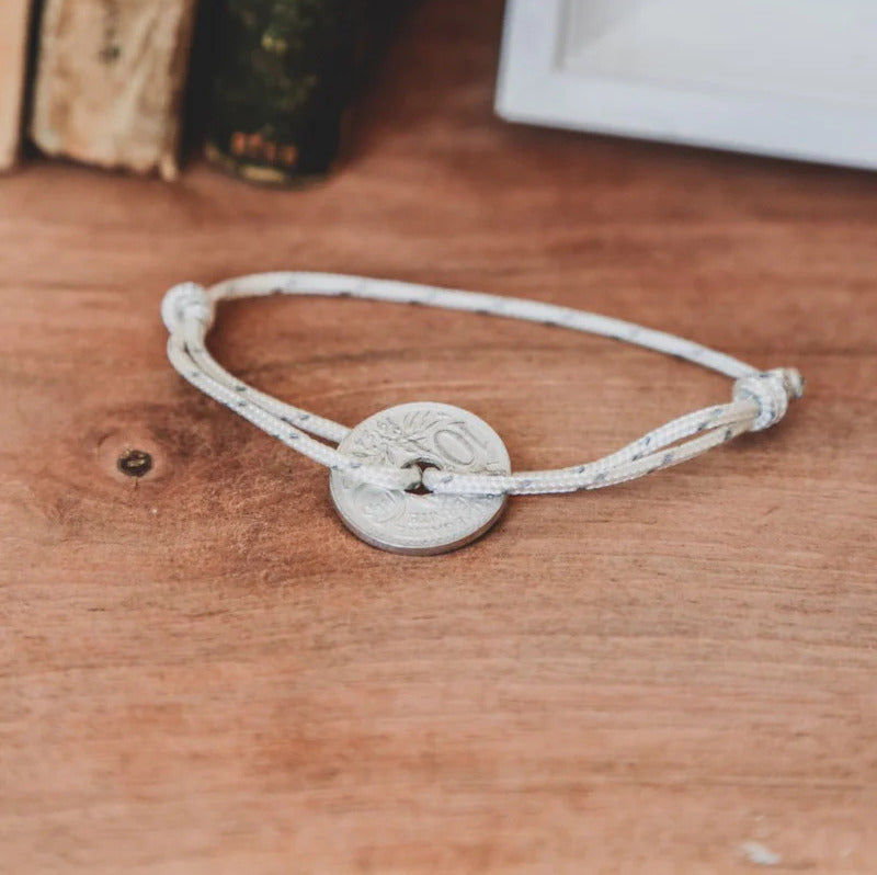 un bracelet cordon blanc unisexe et sa monnaie française le sou trouée
