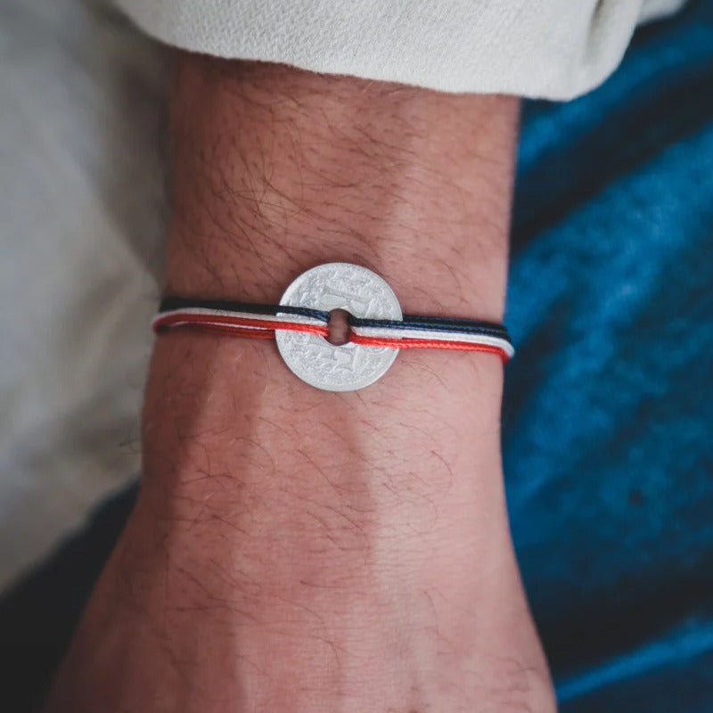 un bracelet cordon ajustable bleu, blanc et rouge et sa pièce de monnaie trouée le sou français