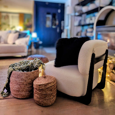 une chauffeuse en tissu bouclette blanc et une struture en bois foncé profonde et confortable. Maison gabin décoration