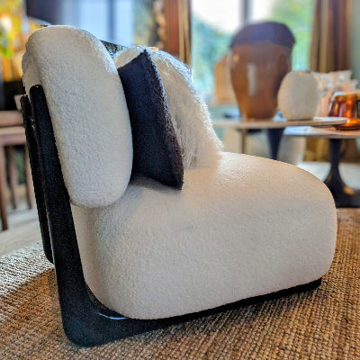 Une chauffeuse en tissu bouclette blanc en lin renforcée par une armature en bois, assise profonde et rembourrée. Maison Gabin decoration