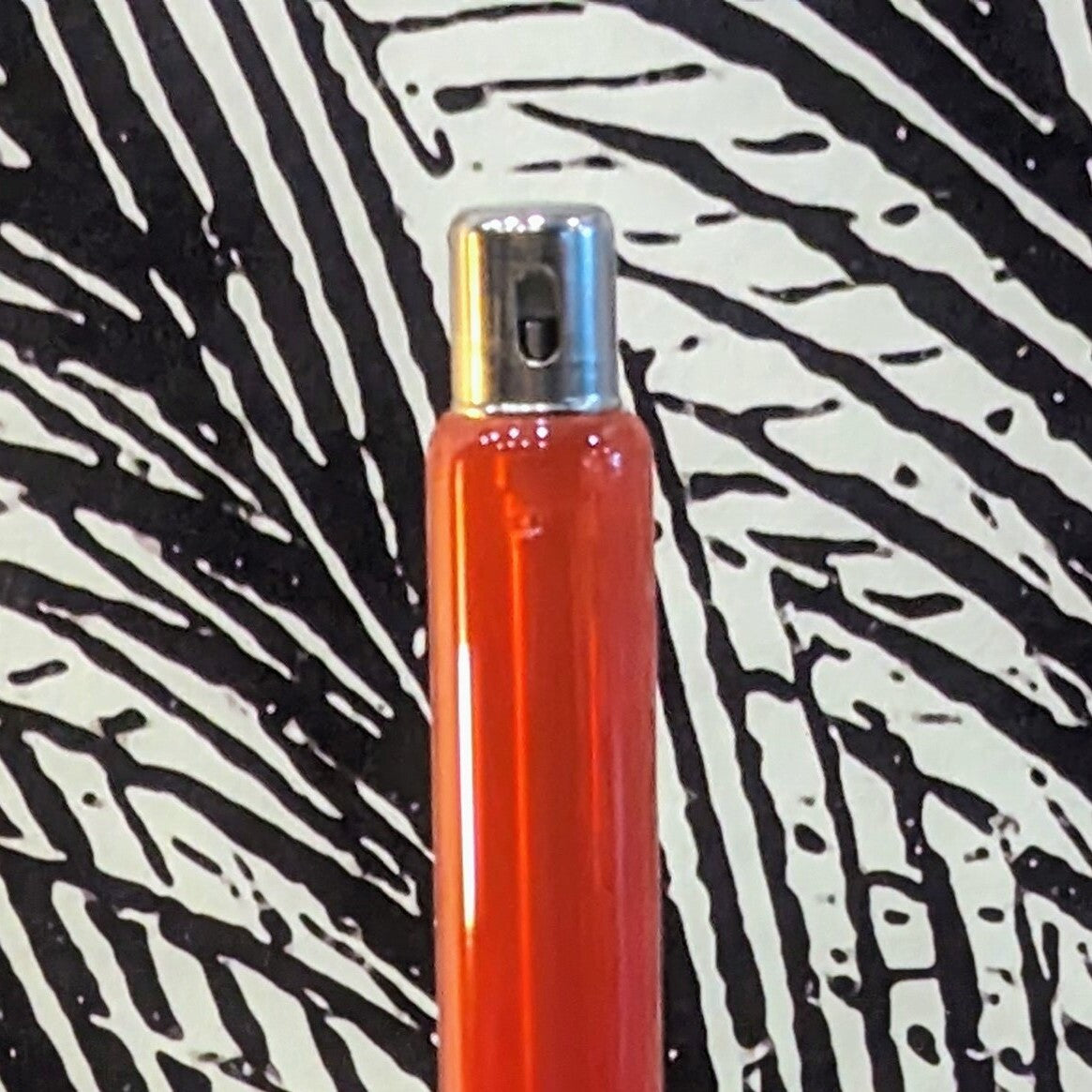 partie flamme du chandelier à huile de paraffine en verre de couleur orangé. Le capuchon est retiré pour l'utilisation