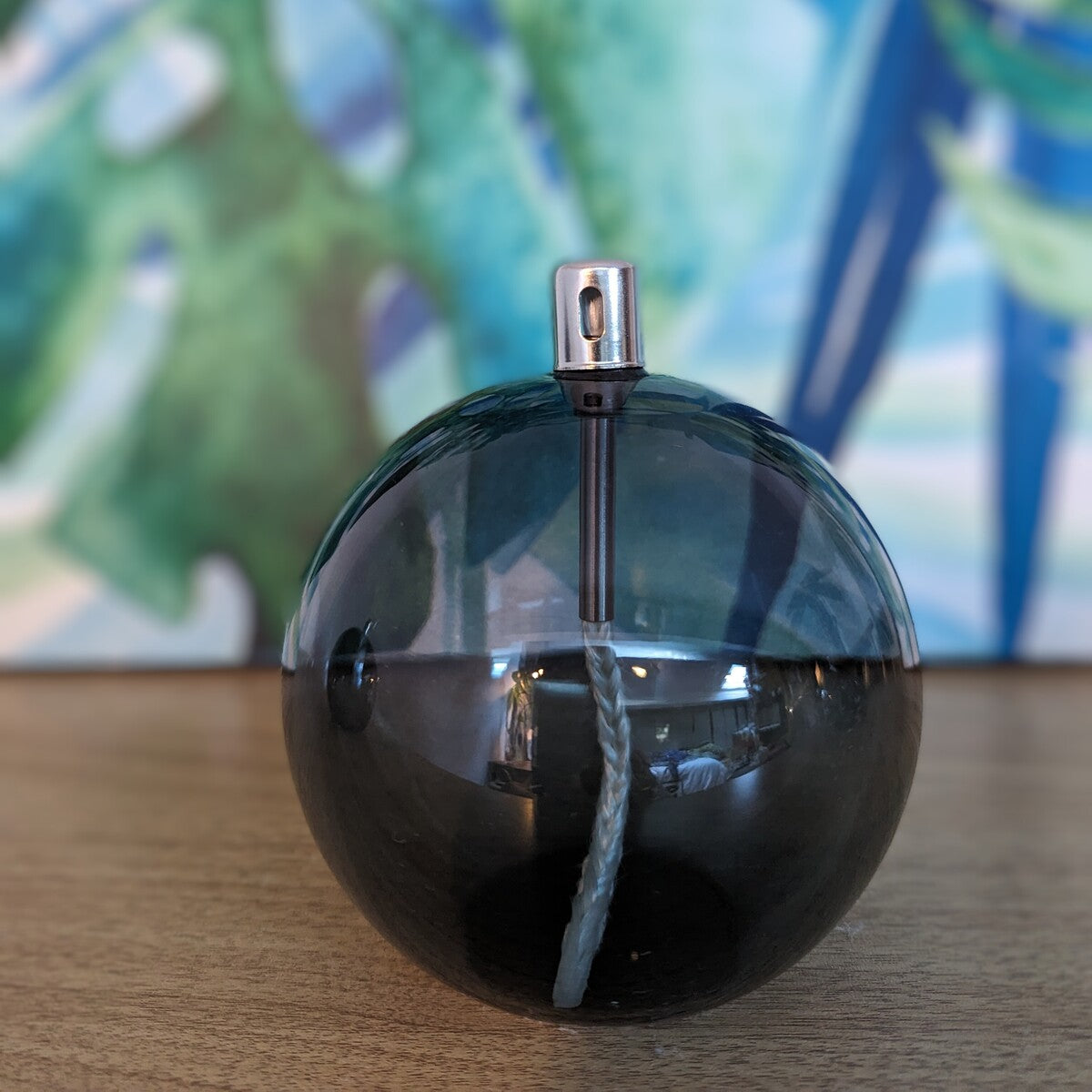 sphère lampe à huile taille M avec sa mèche en coton vue à travers le verre fumé gris