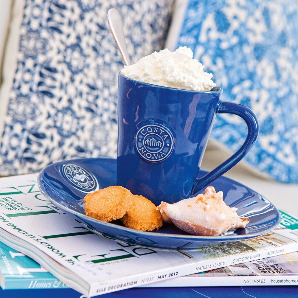 un mug bleu denim posé sur une assiette à dessert de la même couleur, les 2 vaisselles affichant l'estampille en relief costa nova.Idéal pour le petit déjeuner ou pour une douceur au gouter. Maison gabin decoration