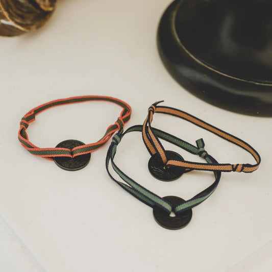 bracelet français avec cordon élastique vert et une pièce de monnaie le sou teintée noire