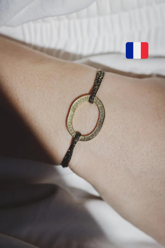 un bracelet femme avec la piece de 10 francs plaquée or et un cordon irisé noir réglable. maison gabin décoration