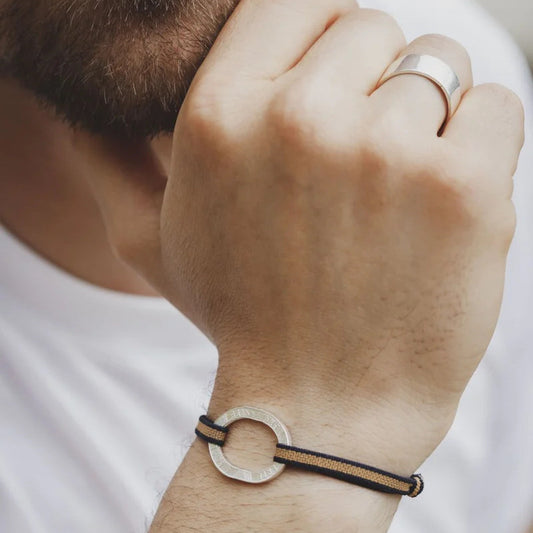bracelet en cordon élastique ambre et noir avec une pièceévidée de 10 francs