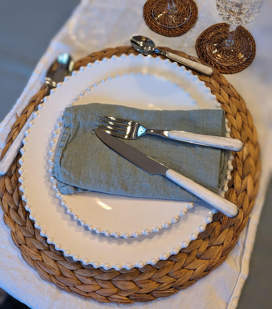 un chemin de table blanc en lin avec une vaisselle à perles, une serviette bleu mint et des couverts imprimé bois blanchi. Maison Gabin Décoration 