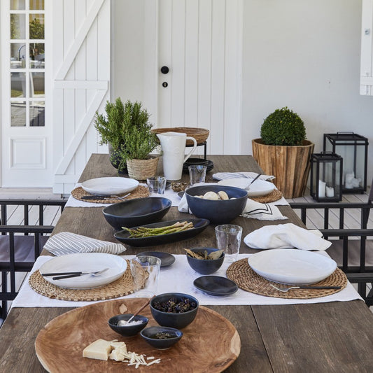 chemin de table blanc sur une table en bois avec des sets en fibres naturelles et une vaisselle blanche
