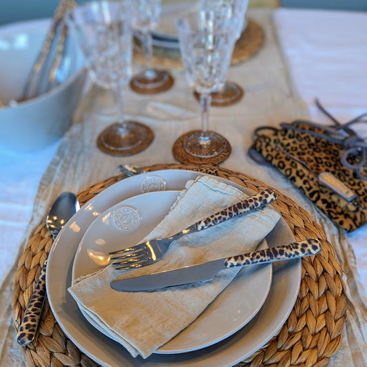 nappe blanche 100% lin avec un chemin de table beige en lin, une vaisselle de la même couleur et des couverts léopard